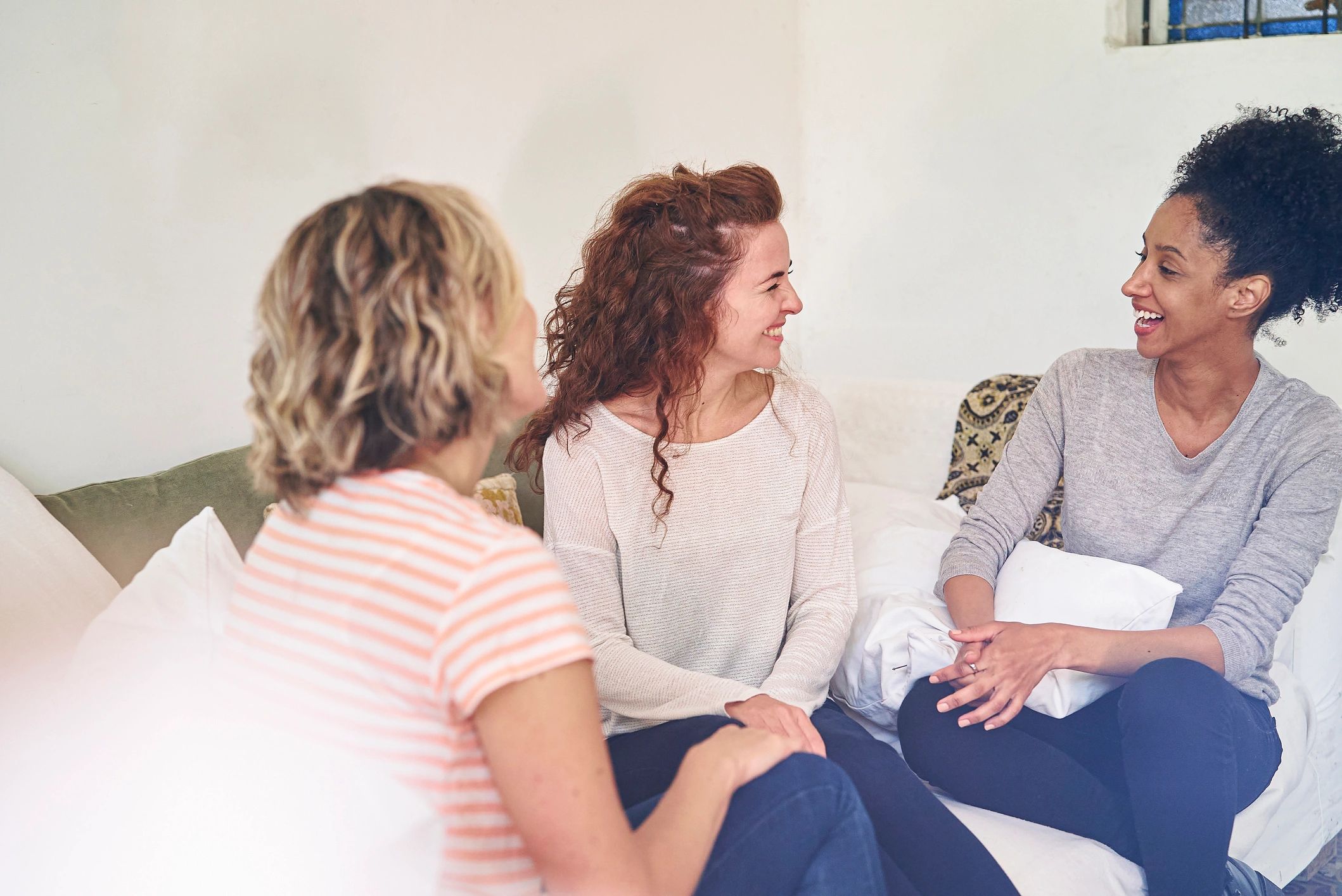 Several women sitting together and talking in a supportive group setting