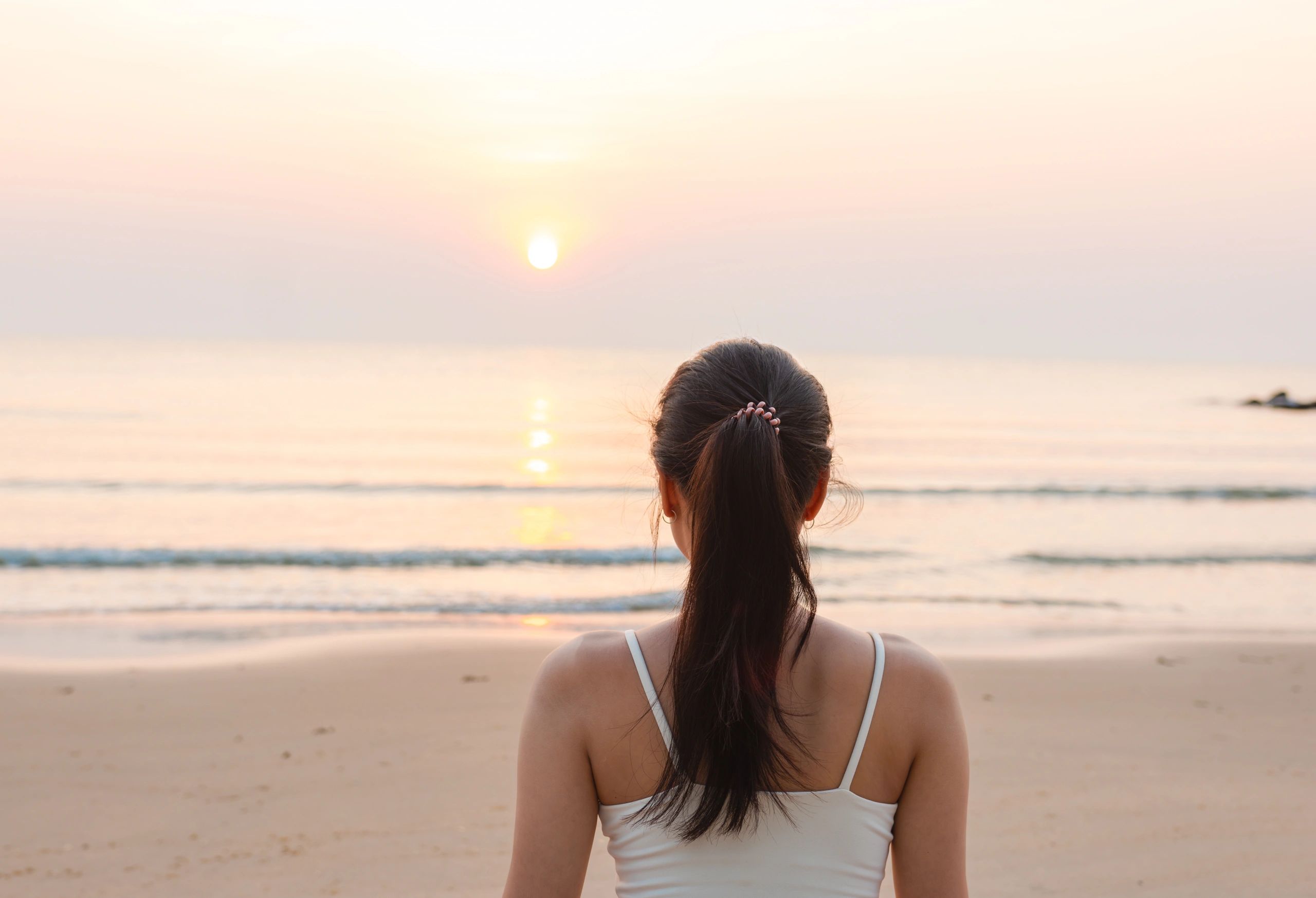 Woman meditating peacefully at sunrise